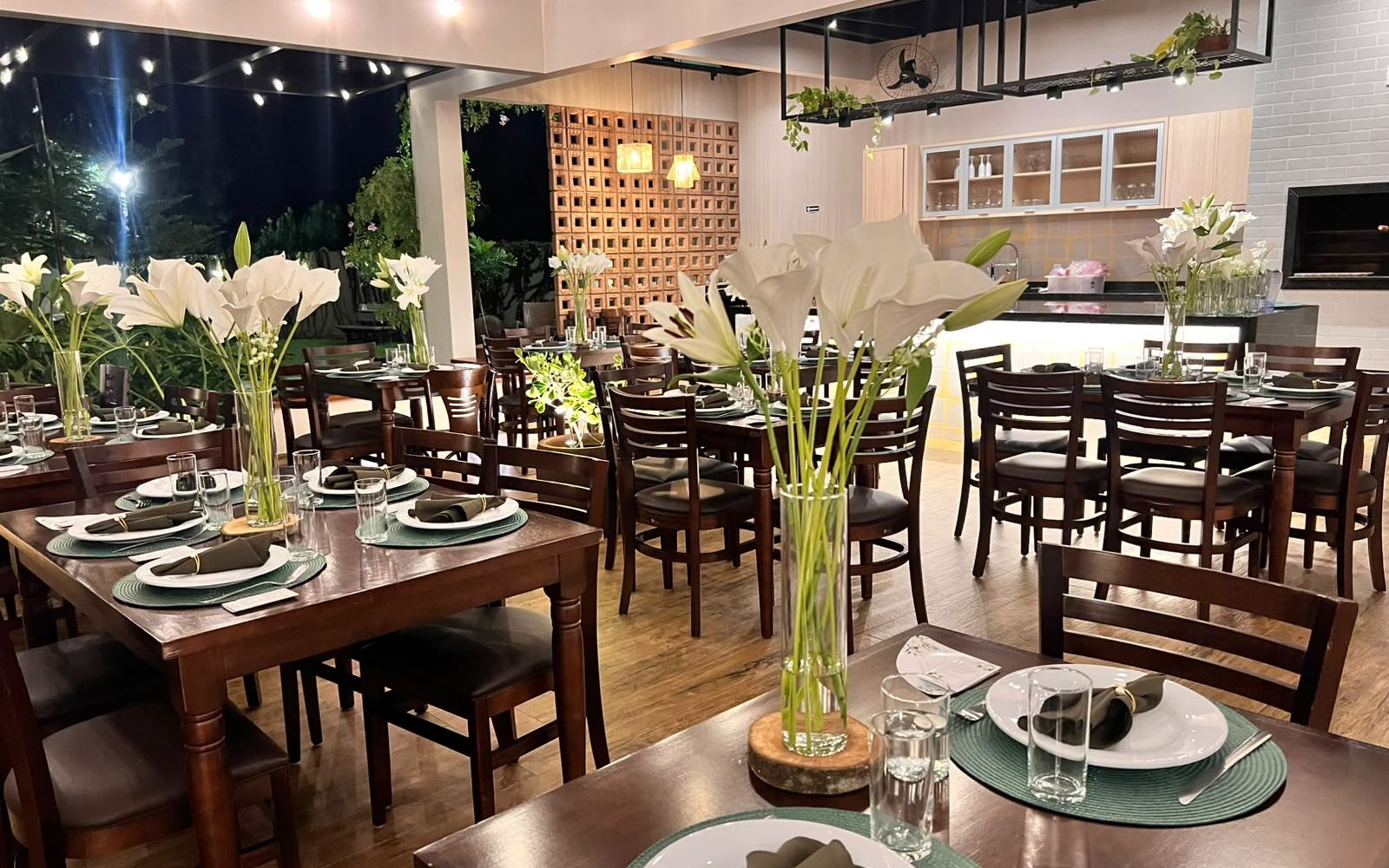 Salão do Festou à noite montado para casamento intimista com lírios e luzes de varal, Realeza PR