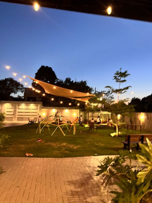Jardim do Festou à noite com luzes de varal e vela de sombra para festas ao ar livre