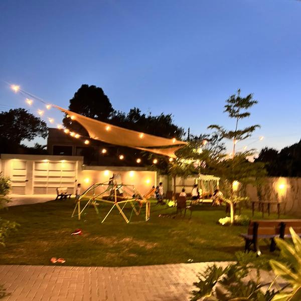 Jardim do Festou à noite com luzes de varal e vela de sombra para festas ao ar livre