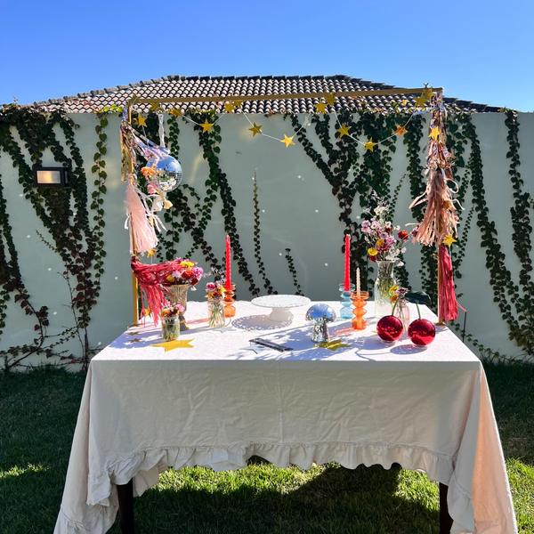 Mesa de festa diante da parede de hera decorada com estrelas