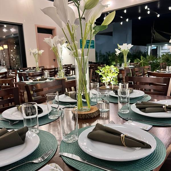 Detalhe de mesa posta com lírios e guardanapos verdes