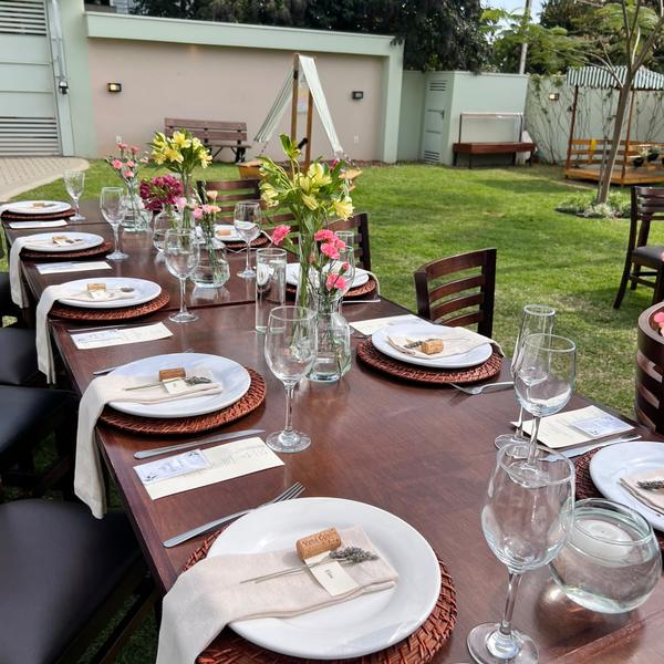 Mesa posta no jardim com flores para almoço de família em Realeza