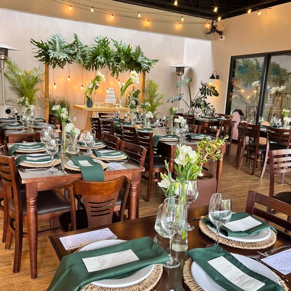 Mesas postas com guardanapos verdes e mesa do bolo para mini wedding no Festou